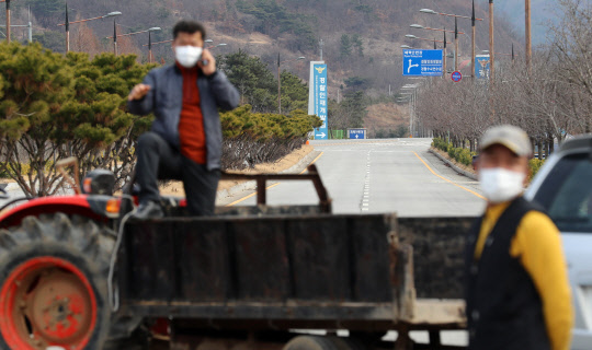마스크 쓰고 진입로 차단… 뿔난 아산 민심  정부가 충남 아산과 충북 진천 공무원 교육시설에 우한 교민을 격리수용 할 것으로 알려진 29일 오후 아산 주민들이 경찰인재개발원 진입로를 가로막고 있다.  연합뉴스